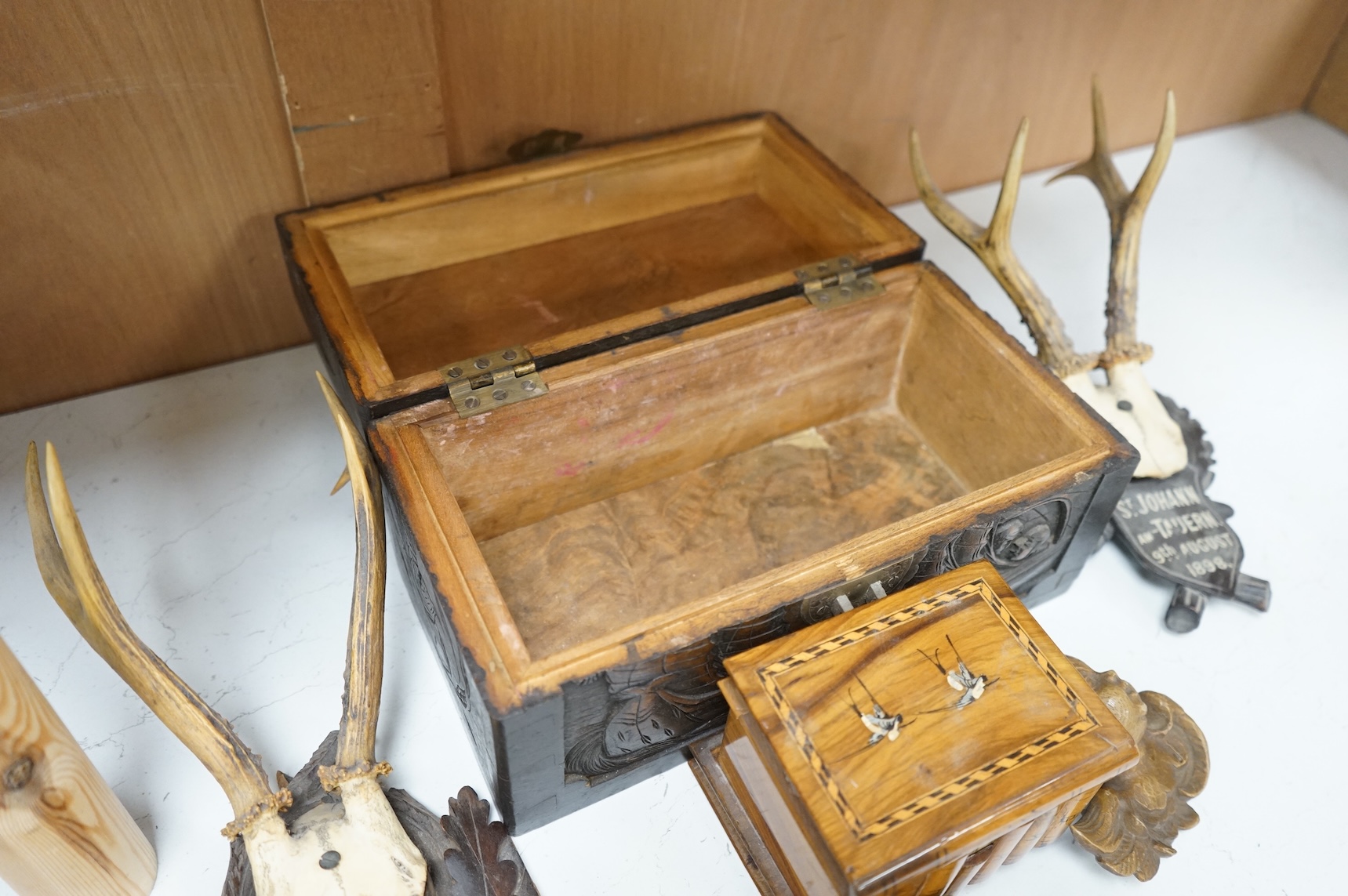 A Chinese carved wood box, two pairs of mounted deer horns, two carved wood cherub heads, an ashtray and an olivewood box, large box 29.5cm x 15cm high. (7)